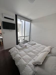 1 dormitorio blanco con 1 cama grande y ventana grande en PATAGONIA FLAT en Esquel