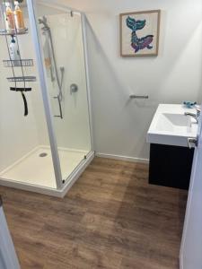 a bathroom with a shower and a sink at Ultimate Beach Front in Waimarama
