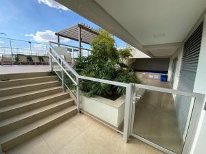 un balcón con escaleras y plantas en un edificio en Apto c/vista próx a faculdade /hospitais PC2302 en Goiânia