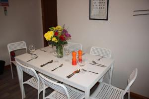 a white table with chairs and a vase of flowers at Taigh Munro in Aviemore