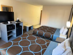 ein Hotelzimmer mit einem Bett und einem Flachbild-TV in der Unterkunft Super 8 by Wyndham Columbia Clark Lane in Columbia
