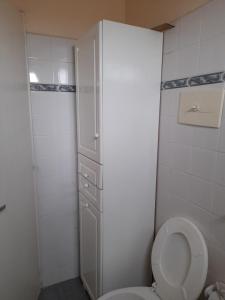 a white bathroom with a toilet and a cabinet at Casa en Potrero de Garay in Potrero de Garay