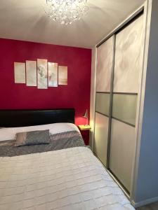 沃爾珊阿貝的住宿－Beautiful Peaceful Studio Flat，一间卧室设有一张床和红色的墙壁