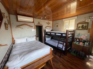 1 dormitorio con 1 cama y 1 litera en 九份山海灣民宿 I 近老街 l 海景檜木房, en Jiufen