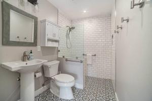 a white bathroom with a toilet and a sink at One bedroom retreat full kitchen/laundry 1GB Wi-Fi in Bonita +3 photos