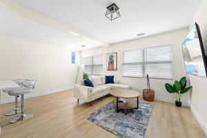 a living room with a couch and a table at Recently Remodeled Mins from beach+Putting Green in Boynton Beach