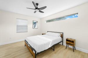 1 dormitorio con 1 cama y ventilador de techo en Recently Remodeled Mins from beach+Putting Green, en Boynton Beach