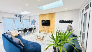 ein Wohnzimmer mit einem blauen Sofa und einem Tisch in der Unterkunft Modern Great West 6 Bed Large house with Parking & WorkSpace in Brentford