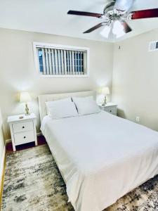 a white bedroom with a bed and a ceiling fan at North Bethesda Gem in Rockville