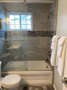 a bathroom with a tub and a toilet and a shower at North Bethesda Gem in Rockville