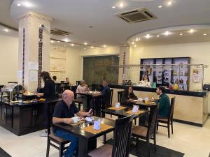a group of people sitting at tables in a restaurant at Than Thien - Friendly Hotel in Hue