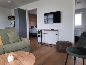 a living room with a couch and a tv on a wall at Stracta Apartments in Kirkjubæjarklaustur