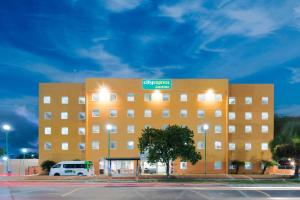 een groot bruin gebouw met een bord erop bij City Express Junior by Marriott Ciudad del Carmen Aeropuerto in Ciudad del Carmen