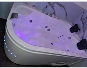 a white bath tub with purple lighting in a bathroom at Hotel Casa Shami in Cusco