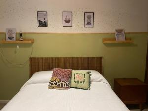 um quarto com uma cama com duas almofadas em Casa Araucarias Refugio Natural en la Ciudad em Posadas