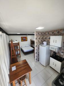 uma pequena cozinha com uma mesa e um frigorífico em Hospedaria Ilhabela - Flats Sul em Ilhabela