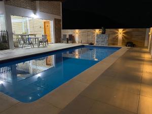 - une piscine d'eau bleue dans une maison dans l'établissement Pousada Mirante dos Canyons, à Praia Grande