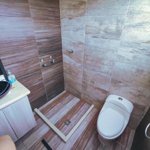 a bathroom with a toilet and a shower at Hotel Ocaso Marinilla in Marinilla