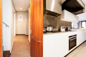 cocina con encimeras blancas y fogones en Bo&Co Apartments, en Sitges