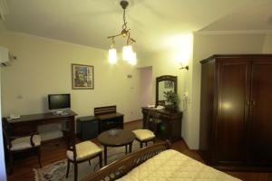 a living room with a table and chairs and a television at Aegeon Hotel in Karlovasi