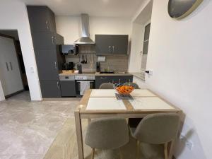 Kleine moderne 3-Bett Wohnung/Apartment : مطبخ مع طاولة خشبية مع كراسي وصحن من البرتقال