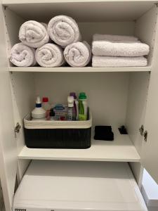 ein Schrank mit Handtüchern und anderen Pflegeprodukten in der Unterkunft Kleine moderne 3-Bett Wohnung/Apartment 