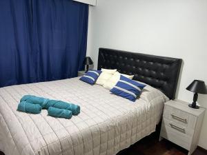 a bedroom with a bed with blue pillows on it at Mendoza Center in Mendoza