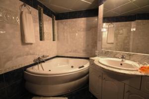 a bathroom with a bath tub and a sink at Aegeon Hotel in Karlovasi