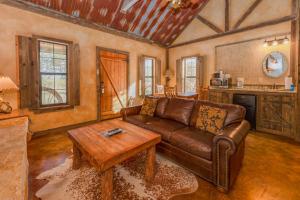 a living room with a leather couch and a table at Country Inn Cottages in Fredericksburg