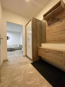 Zimmer mit einem großen Holzschrank und einem Wohnzimmer in der Unterkunft Kleine moderne 3-Bett Wohnung/Apartment 