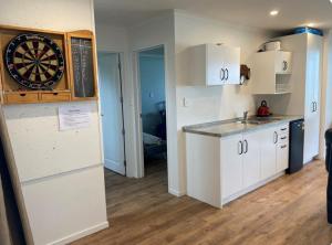 a kitchen with a dart board on the wall at Ultimate Beach Front in Waimarama