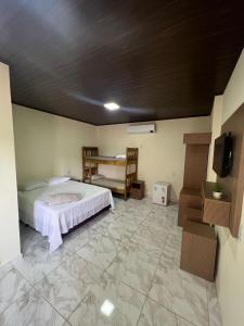 a bedroom with a bed and a tv in a room at Bonito Suítes in Bonito