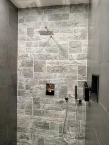 W łazience z kamienną ścianą znajduje się prysznic. w obiekcie Spa détente pour une nuit unique w Charleroi