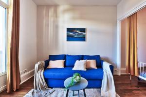 un soggiorno con divano blu e tavolo di Grand T2 entier-5p-2 balcons - Appartement central a Saint-Fons