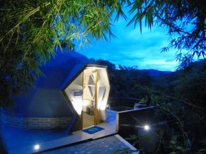 a glass house in the middle of a forest at night at ASGARD Spa in San Agustín