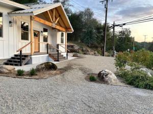 ein kleines Haus mit einer Veranda und einer Kieseinfahrt in der Unterkunft Soleil Luna 2 miles from Sequoia Park Entrance in Three Rivers
