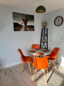 a dining room with a table and chairs and a clock at Cosy Dover Flats, Castle view in Kent