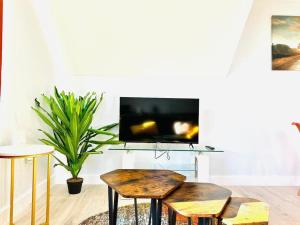 a living room with two tables and a tv at Cosy Dover Flats, Castle view in Kent