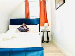 a blue and white bed in a room with a window at Cosy Dover Flats, Castle view in Kent