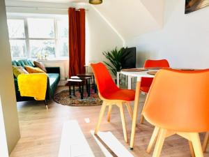 uma sala de estar com cadeiras laranja e uma mesa em Cosy Dover Flats, Castle view em Kent