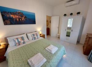 ein Schlafzimmer mit einem großen Bett und einer grünen Decke in der Unterkunft Casa Armilla in La Spezia