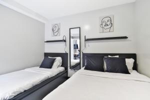 a bedroom with two beds and a mirror at Parc Avenue Lofts in Montreal
