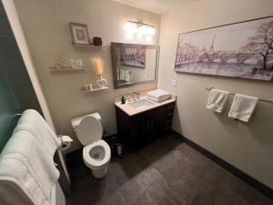 y baño con aseo, lavabo y espejo. en Luxury Modern Condo 3-min from Six Flags w/PS5, 1GB Fast Wi-fi Kingbed, en Santa Clarita