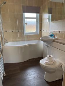 a bathroom with a tub and a toilet and a sink at Ness Lodge in Little Habton +9 photos
