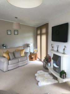 a living room with a couch and a tv at Ness Lodge in Little Habton