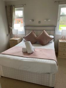 a bedroom with a large bed with two windows at Ness Lodge in Little Habton