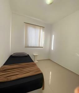 een kleine slaapkamer met een bed en een raam bij Ap exclusivo 2/4 completo in Feira de Santana