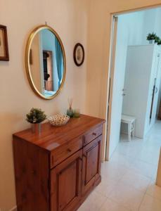 ein Badezimmer mit einer Holzkommode und einem Spiegel in der Unterkunft Casa Armilla in La Spezia