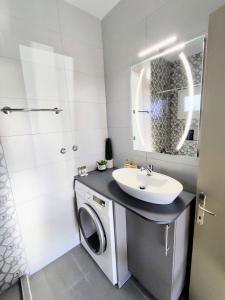 a bathroom with a washing machine and a sink at Georgia's apartment in Pálioura