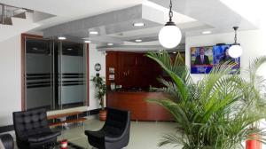 a lobby with two chairs and a reception desk at Hotel El Jardín Cafetero Armenia in Armenia